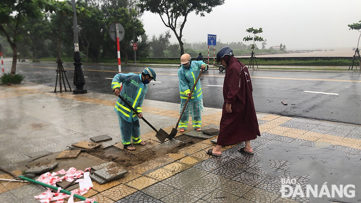 Lực lượng ngành Giao thông khắc phục đường Lê Văn Lương. Ảnh: THÀNH LÂN