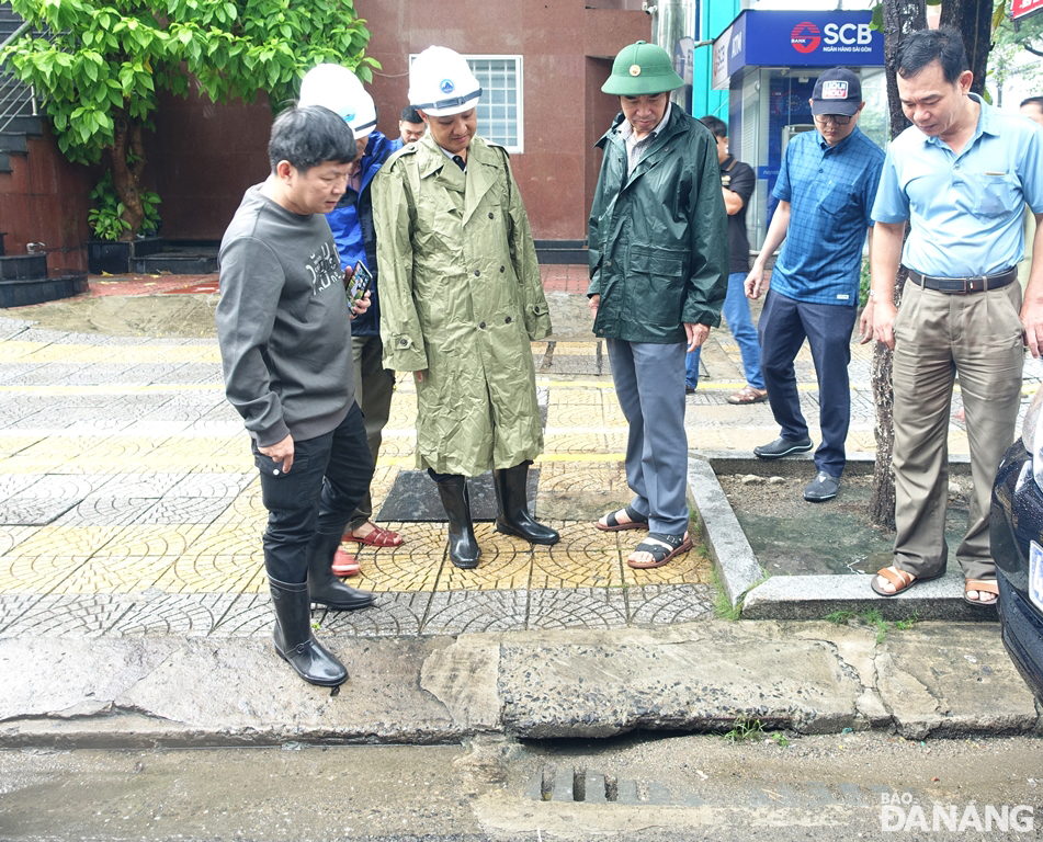 Chủ tịch UBND thành phố Lê Trung Chinh và Phó Chủ tịch UBND thành phố Lê Quang Nam chỉ đạo khẩn trương khơi thông, nạo vét các cửa thu nước mưa bị đất, cát, rác bồi lấp. Ảnh: HOÀNG HIỆP