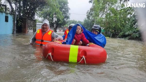 Police officers evacuate people from a flooded area on Me Suot Street on Saturday morning.