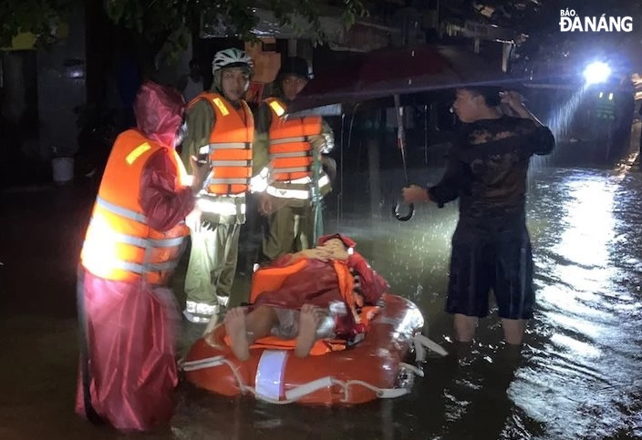 Armed forces in the city take a man in a low-lying area in Hoa Khanh Nam Ward to a safer place on the evening of October 13. Photo: H.T