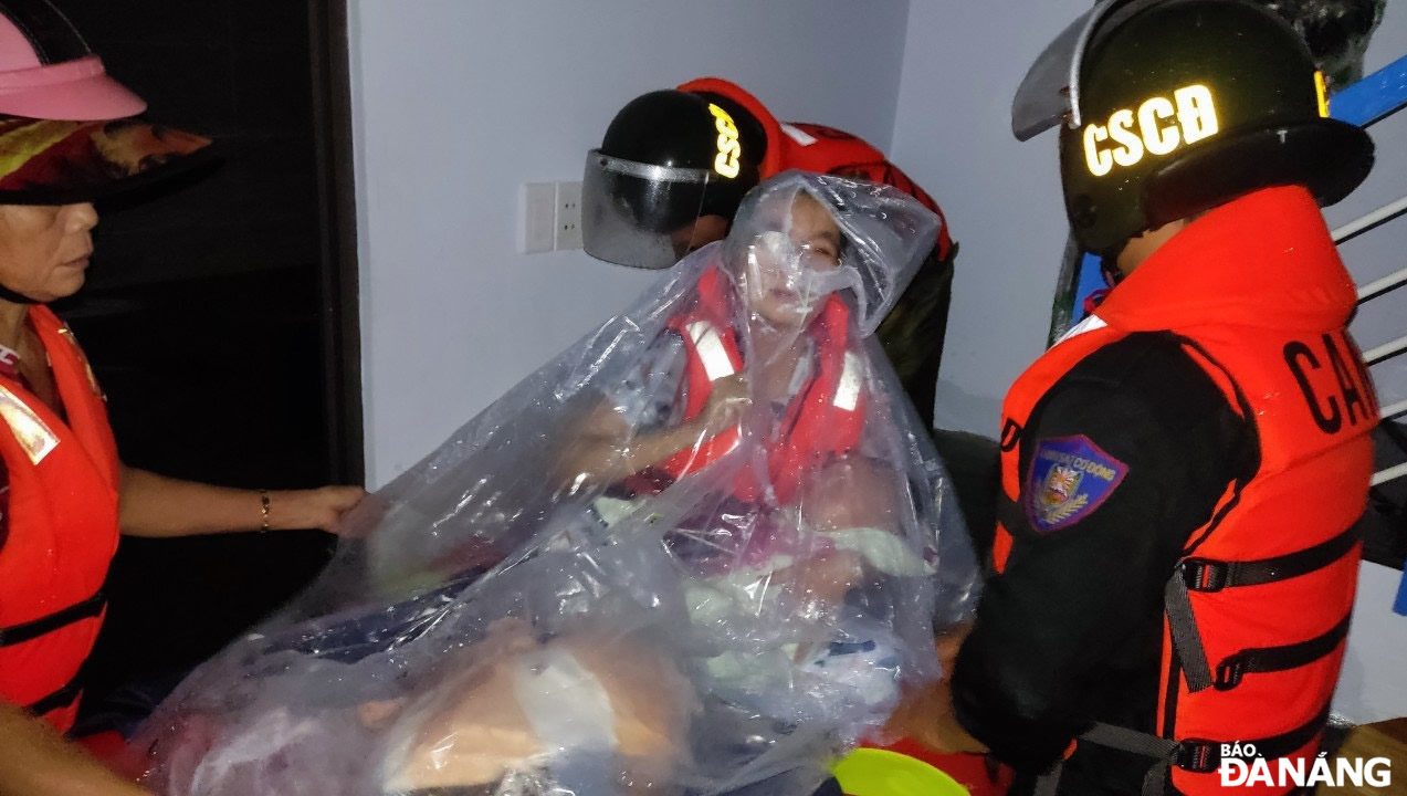 Rescue workers transport a baby and a woman living on Me Suot Street, Hoa Khanh Nam Ward, Lien Chieu District, on a boat to a safer shelter.