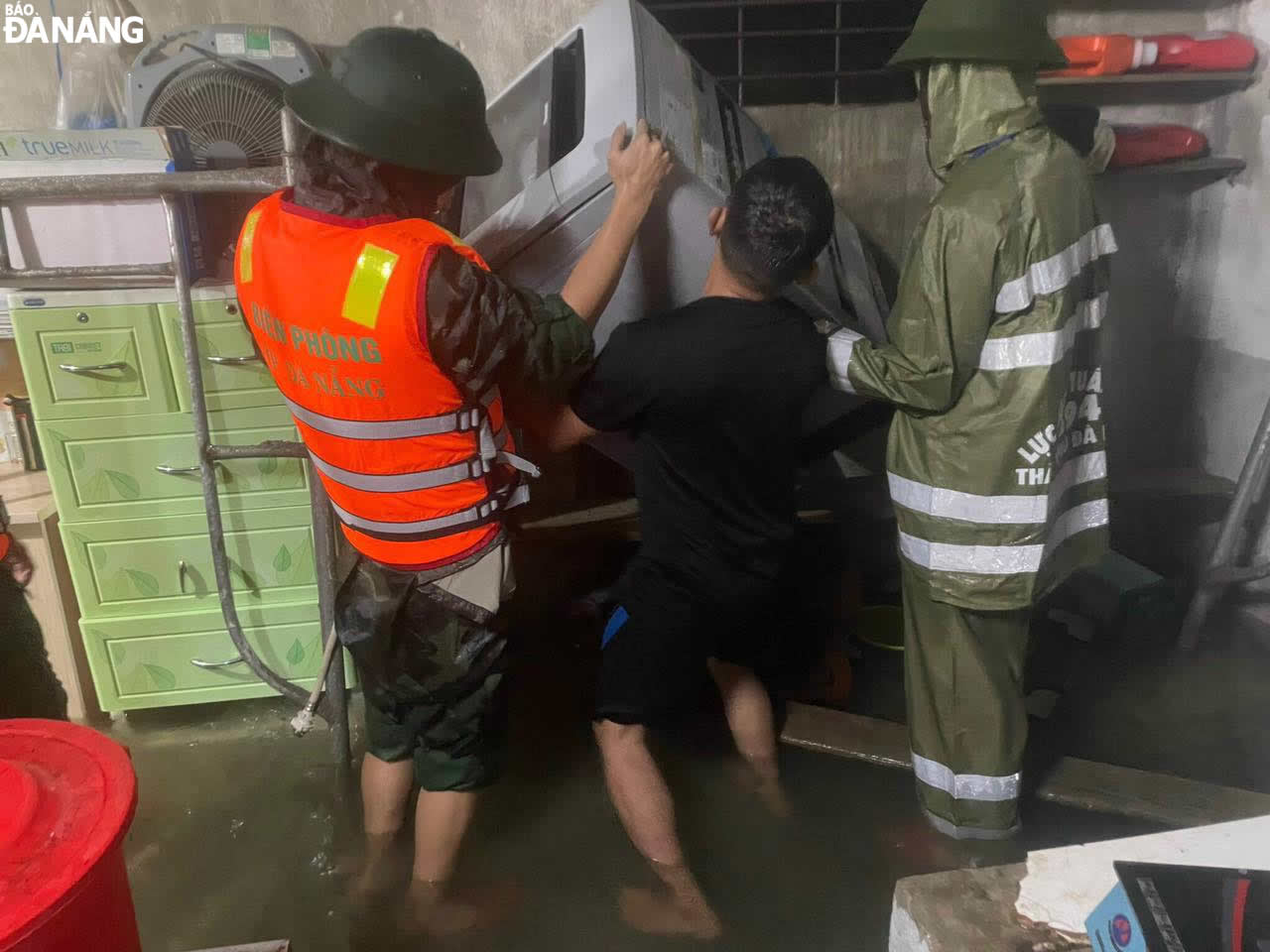 The city's Border Guard officers and men help people carry their assets to higher places avoid damage caused by floods