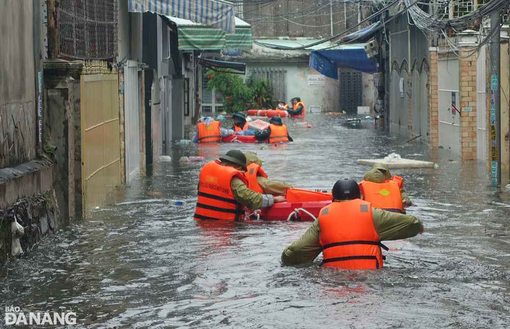 Rescuers move into a deeply flooded alley on Thai Thi Boi Street to evacuate local residents. Photo: HOANG HIEP