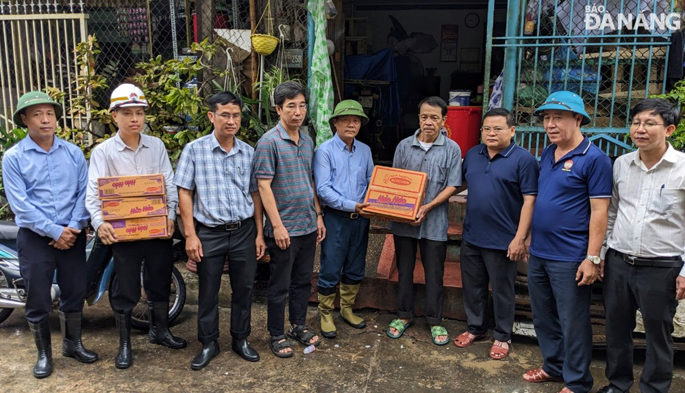 Deputy Chief of the Standing Office of the National Steering Committee for Natural Disaster Prevention and Control Nguyen Van Tien (5th, left), Vice Chairman of the municipal People's Committee Tran Chi Cuong (4th, left), gave spiritual encouragement and donated gifts and necessities for a household that was recently deeply flooded in Thanh Khe District. Photo: H.H