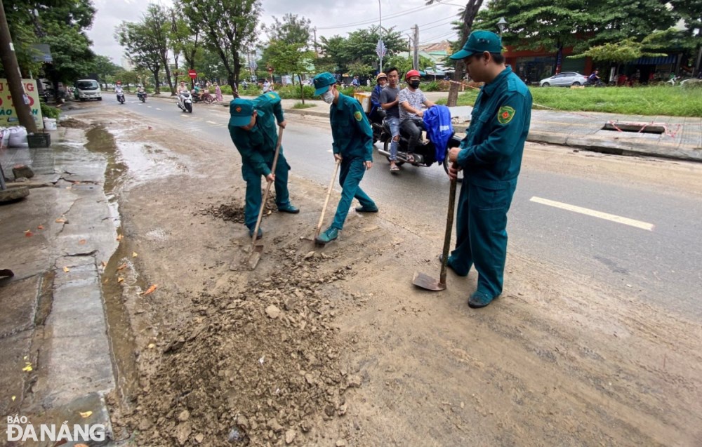 Các lực lượng vệ sinh các đoạn đường bị ngập lụt trên địa bàn quận Cẩm Lệ.