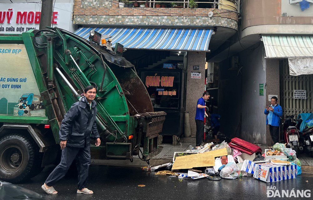 Công ty CP Môi trường đô thị Đà Nẵng huy động phương tiện vận chuyển chờ thu gom rác tại các kiệt bị ngập sâu ở đường Thái Thị Bôi.