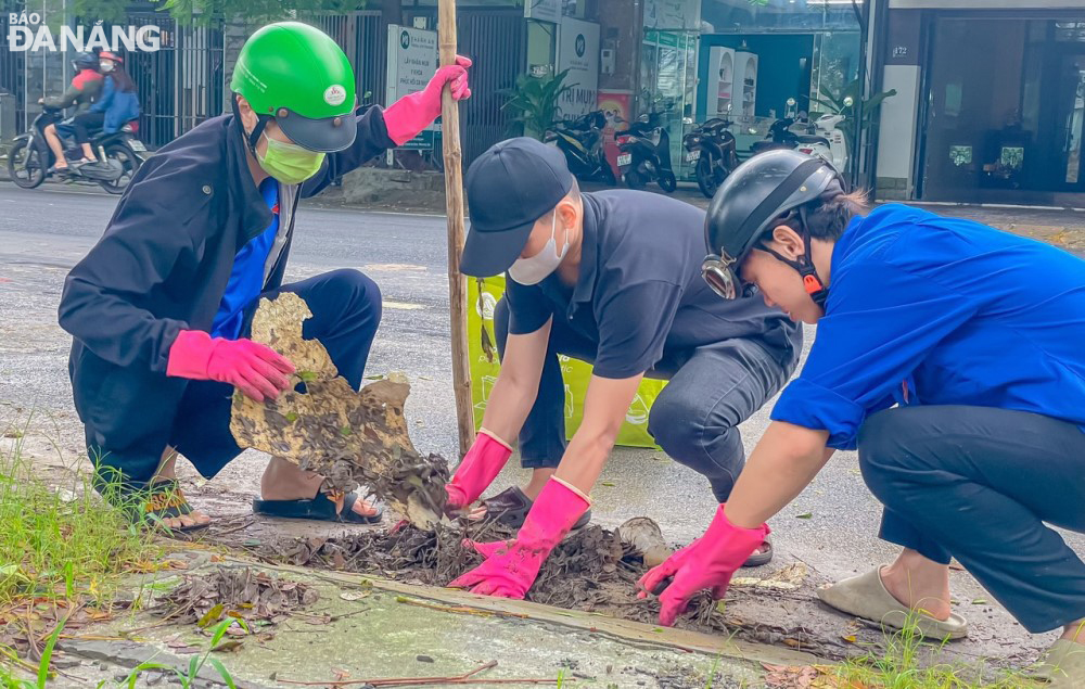 Youth union members of Lien Chieu District remove shielding items and open a rainwater collection gate