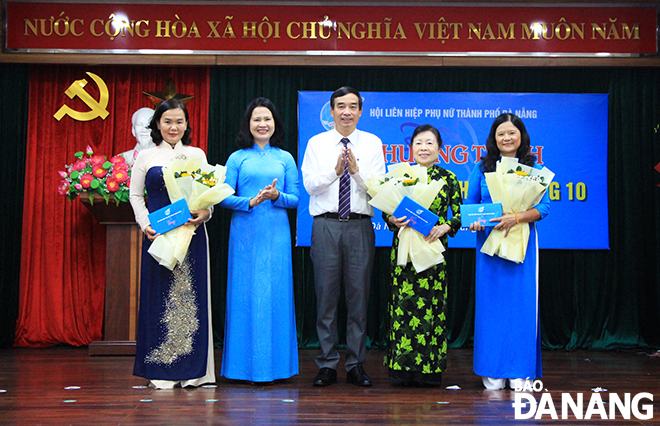 Chairman of the Da Nang People's Committee Le Trung Chinh (middle) presents flowers and gifts to former Chairwomen of the municipal Women's Union. Photo: X.D