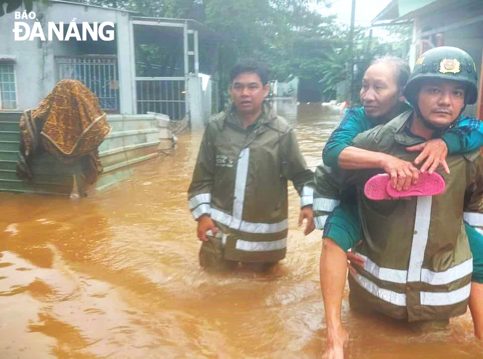 Công an phường Hòa Khánh Nam kịp thời đưa người dân tại kiệt 127 đường Mẹ Suốt đến nơi ở an toàn vào sáng 17-10. Ảnh: C.A