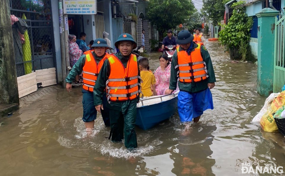 Người dân ở các nhà có nguy cơ ngập sâu được hỗ trợ đi sơ tán.