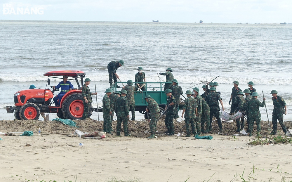Các lực lượng và phương tiện cơ giới được huy động để đẩy nhanh tiến độ thu gom rác tấp vào các bãi biển sau mưa lũ.
