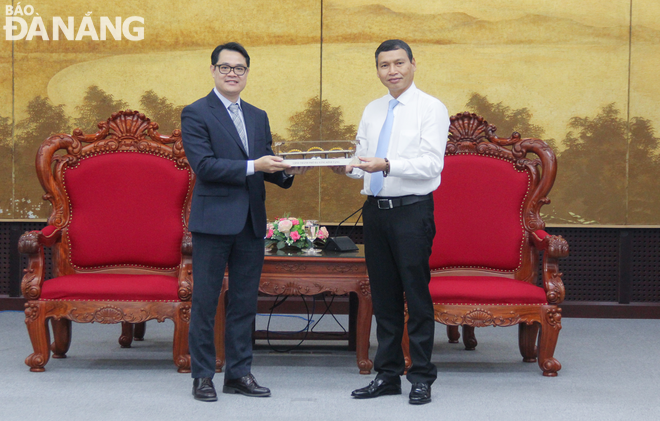 Phó Chủ tịch Thường trực UBND thành phố Hồ Kỳ Minh (phải) tặng quà lưu niệm cho đại diện VINK. Ảnh: M.Q