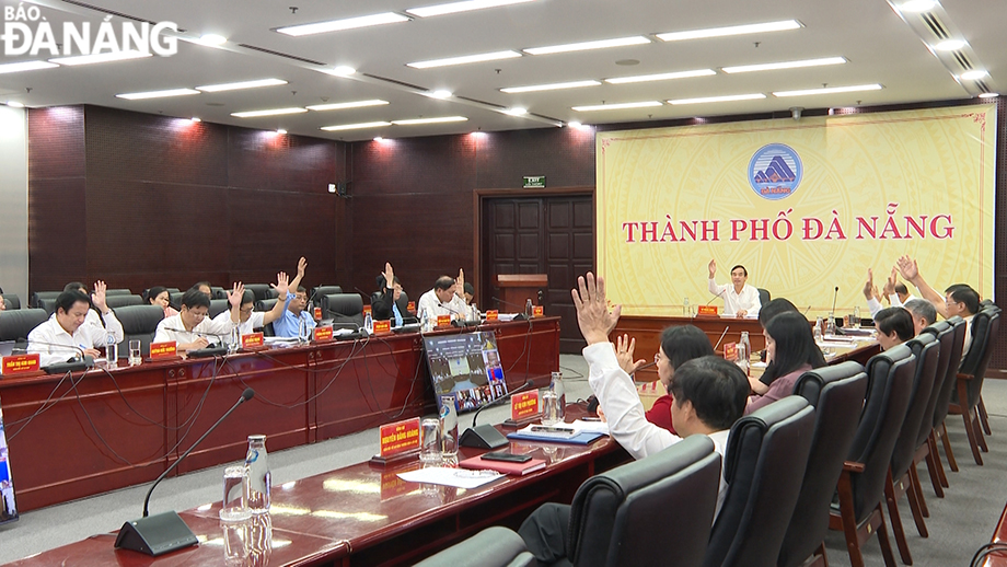 Chủ tịch UBND thành phố Lê Trung Chinh chủ trì phiên họp. Trong ảnh: Các đơn vị tham dự phiên họp biểu quyết thông qua các nội dung của phiên làm việc. Ảnh: THU HÀ