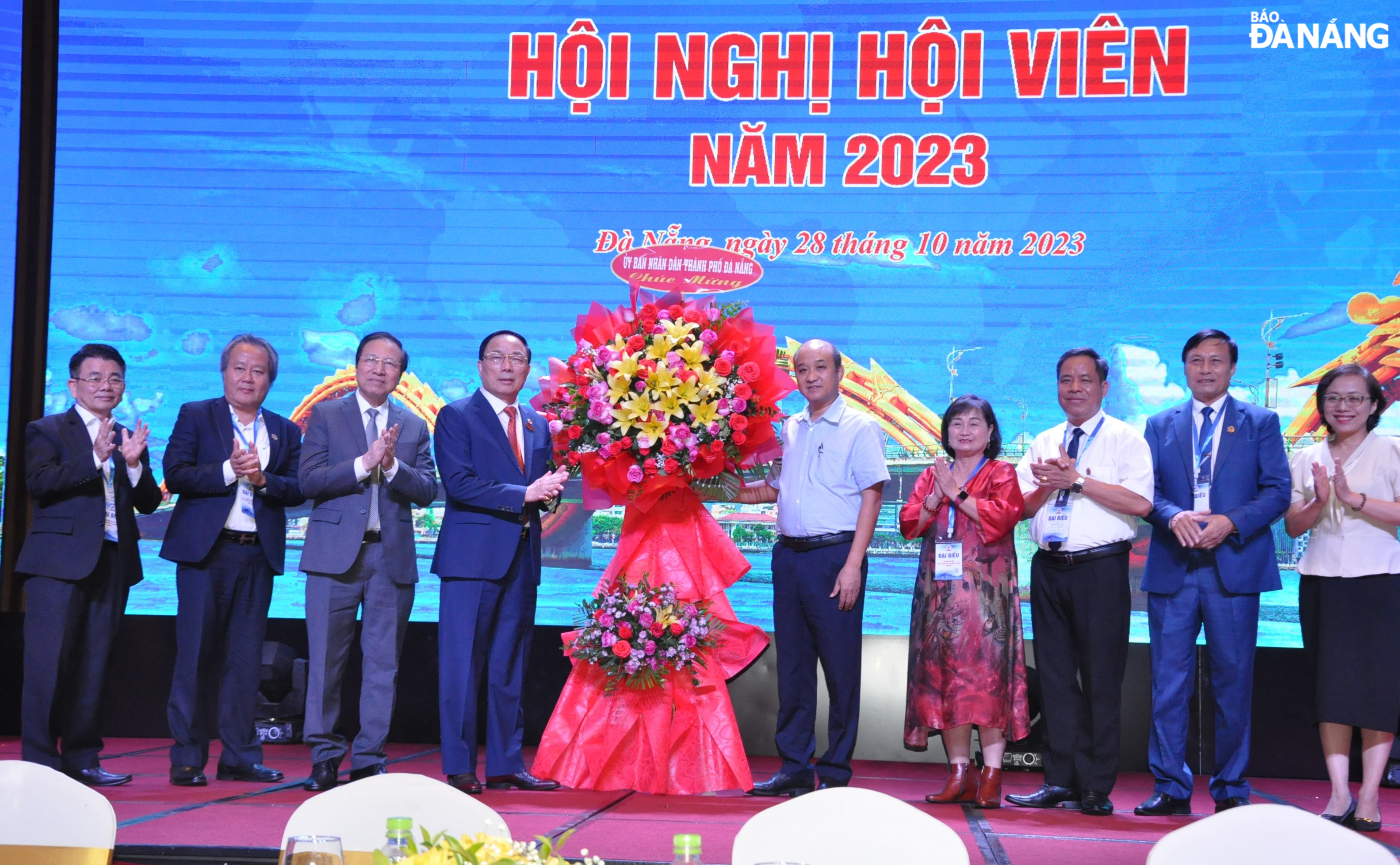 Phó Chủ tịch UBND thành phố Lê Quang Nam (thứ 5, bên phải sang) tặng hoa chúc mừng hội nghị. Ảnh: LÊ HÙNG