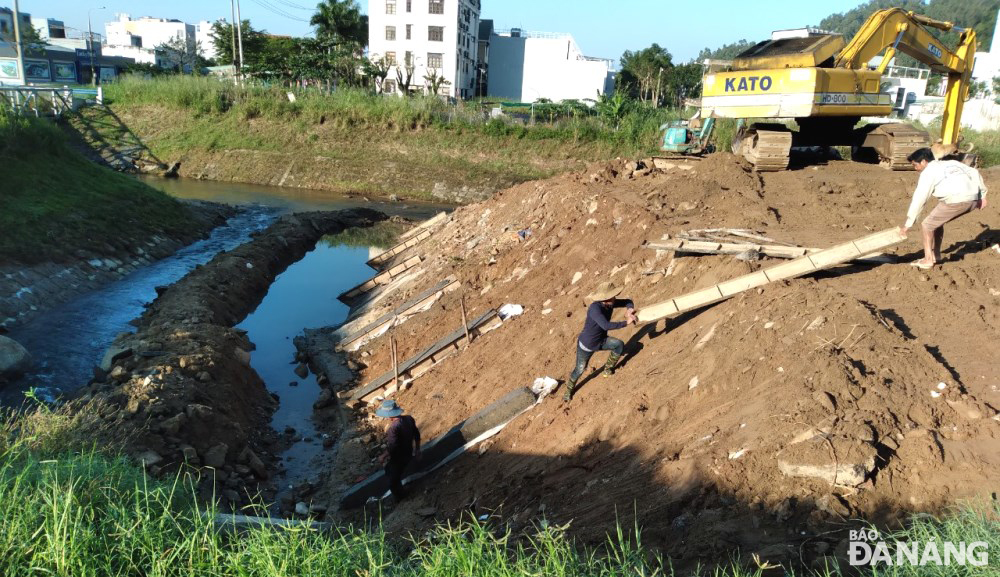 Các công nhân đang tranh thủ thời tiết thuận lợi để thi công khắc phục sạt lở tại khu vực hạ lưu suối Đá (quận Sơn Trà) trước khi mưa lớn. Ảnh: HOÀNG HIỆP