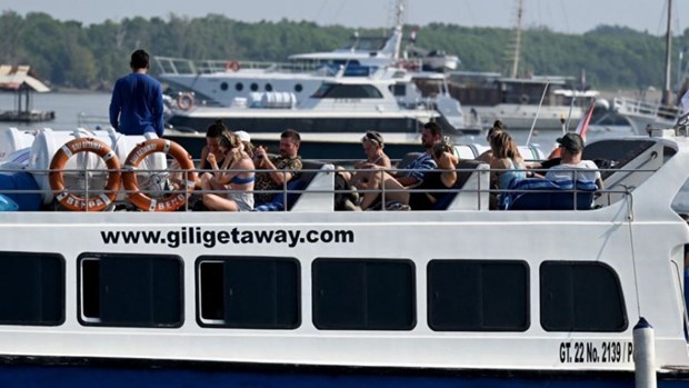 Foreign tourists are seen on December 31 last year aboard a fast boat at a pier on Serangan Island, Bali. (Photo: AFP/VNA)