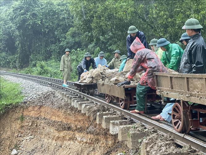 Lực lượng chức năng khẩn trương gia cố vị trí đường sắt Bắc Nam đoạn qua Hà Tĩnh bị sạt lở. Ảnh: TTXVN phát