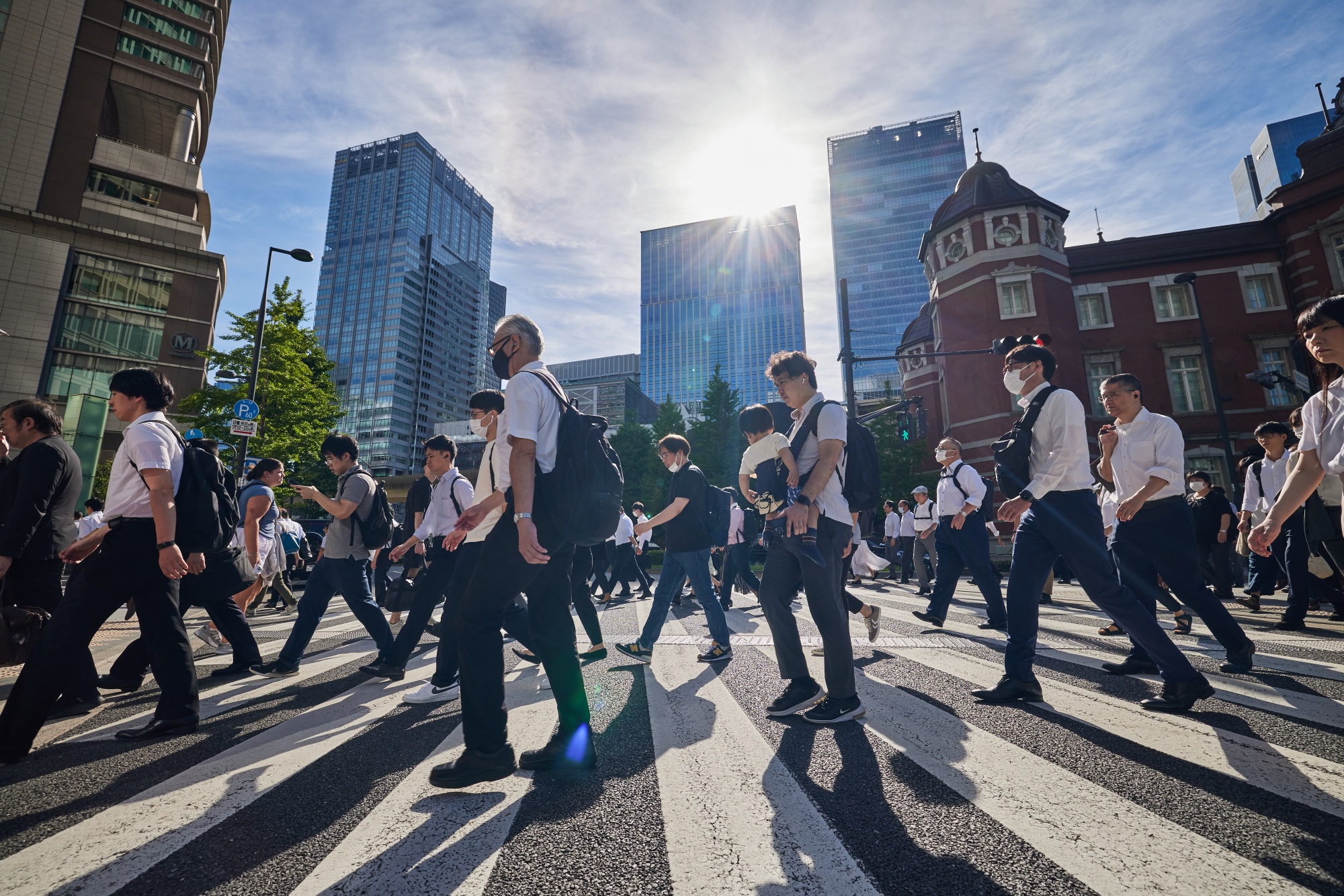 Người dân hối hả rảo bước trên đường trong buổi sáng ở bên ngoài nhà ga Tokyo (Nhật Bản). Ảnh: Bloomberg