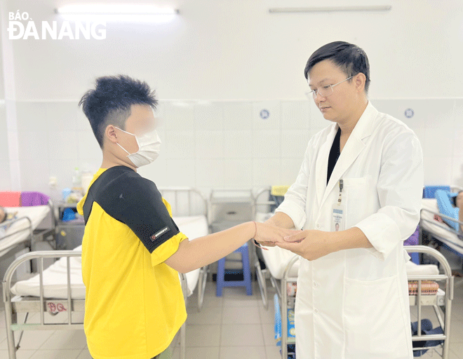 Bác sĩ Bệnh viện Đà Nẵng khám, hướng dẫn tập phục hồi chức năng cho bệnh nhi đột quỵ. Ảnh: PHAN CHUNG