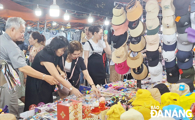 Tourists are pictured shopping for favourite products at a night market in Da Nang. Photo: DNO