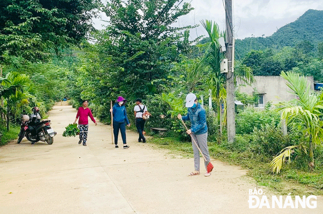 Người dân thôn Tà Lang ra quân quét dọn rác, bảo vệ môi trường Ảnh: H.V