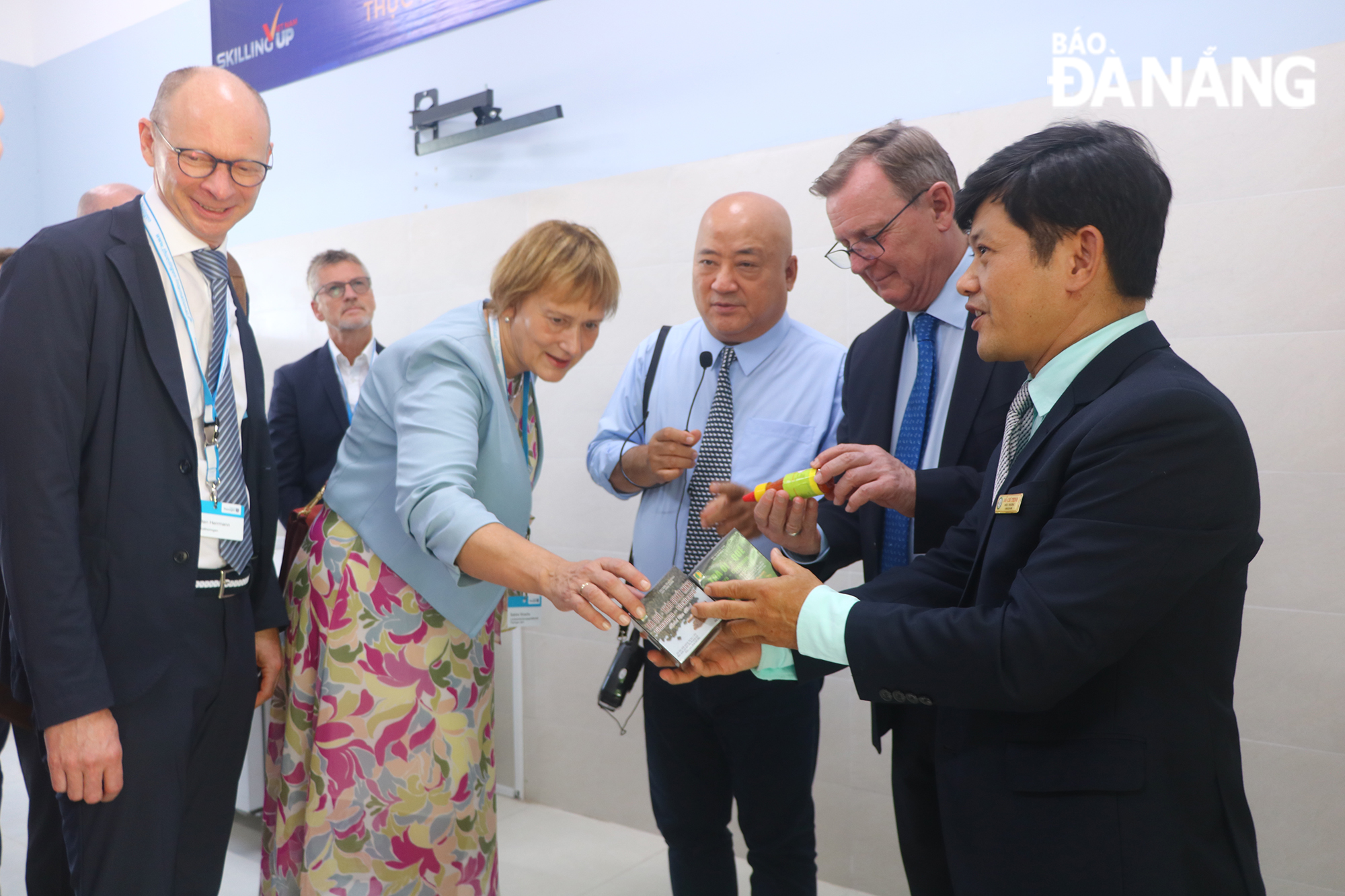 Dr. Do Chi Thinh (first, right), Principal of the Da Nang College of Food Industry, introduces his school's products to the delegation of Thuringen state. Photo: VAN HOANG