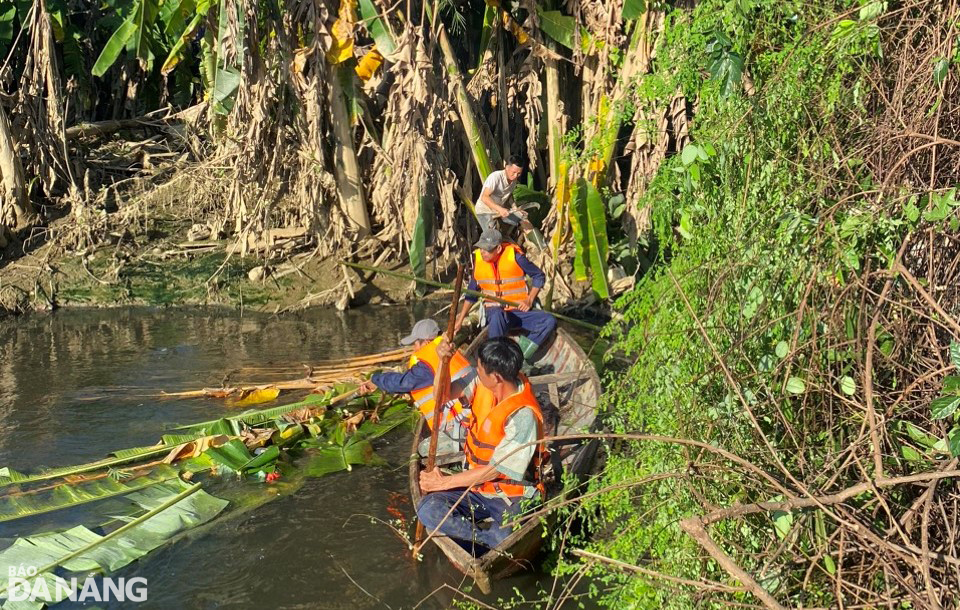 Các công nhân phát quang cây cối, bụi rậm và thu gom rác dọc tuyến kênh thoát nước ở khu vực đường Mẹ Suốt. Ảnh: PV