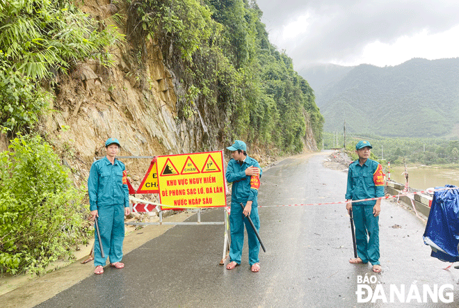 Lực lượng dân quân xã Hòa Bắc (huyện Hòa Vang) chốt chặn tại khu vực sạt lở đoạn qua đèo La Ngà (xã Hòa Bắc) để bảo đảm an toàn cho người dân trong quá trình di chuyển qua đây vào sáng 13-11. Ảnh: THANH NHÂN	
