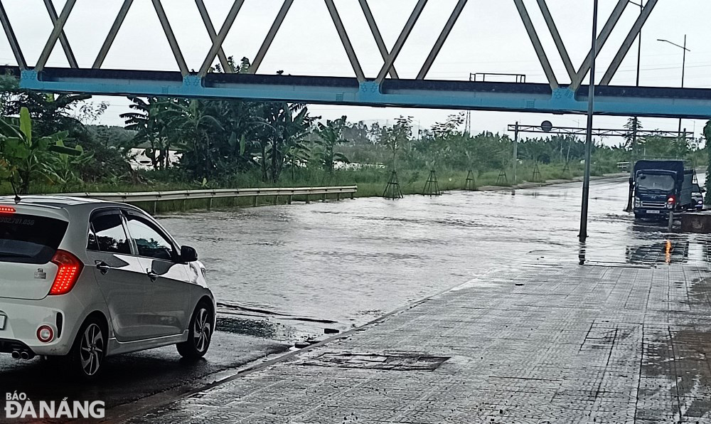 The Cam Le River has overflowed its banks, sending a large amount of water to flood a low-lying section of Thang Long Street. Photo: TRAN TRUC