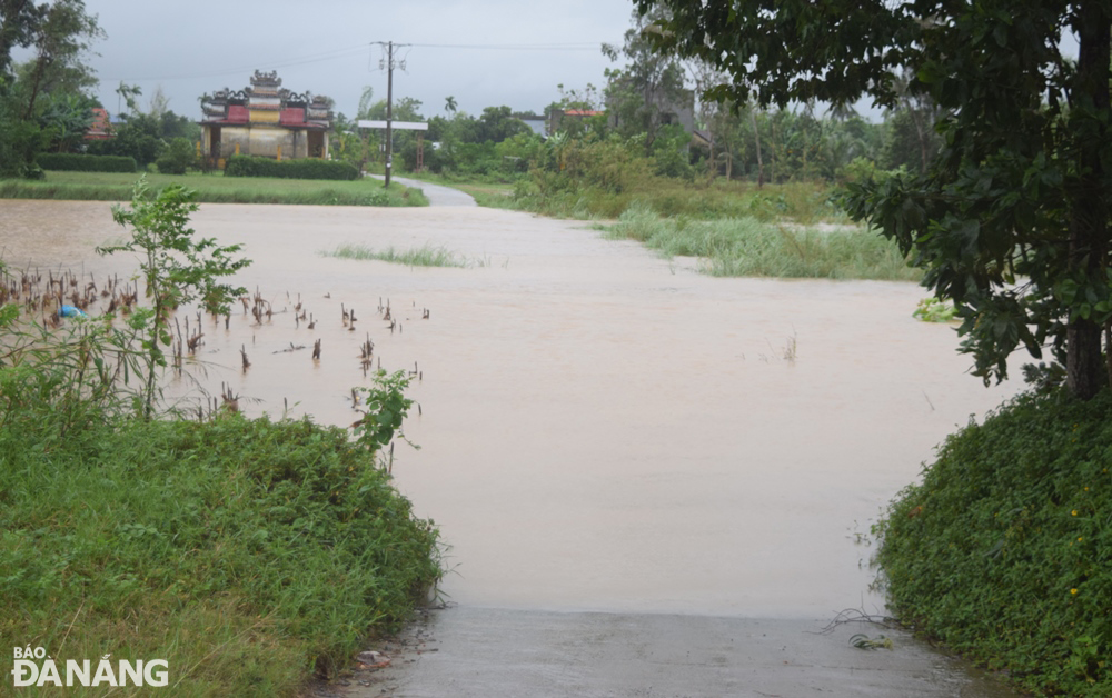 The low-lying road connecting Hoa Tien Commune to Dien Tien Commune, Dien Ban Town, Quang Nam Province was submerged under water on Tuesday afternoon fter the Yen River overtopped its banks as a result of heavy rains.  Photo: HOANG HIEP