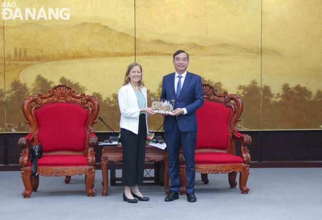 Da Nang People's Committee Chairman Le Trung Chinh (right) presents a gift to Mrs. Aler Grubbs, Director of the United States Agency for International Development (USAID) in Viet Nam