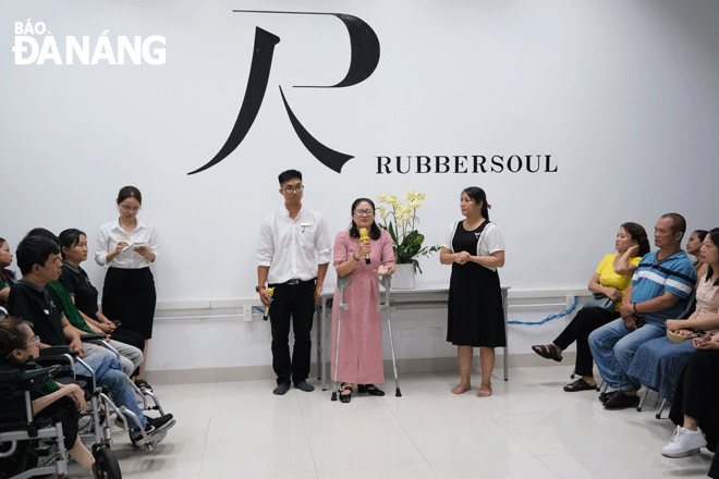 Phó Chủ tịch Hội Người khuyết tật thành phố Đặng Hương Giang (giữa) động viên người khuyết tật nỗ lực để gắn bó, đồng hành cùng Công ty TNHH Rubbersoul Việt Nam. Ảnh: XUÂN HẬU