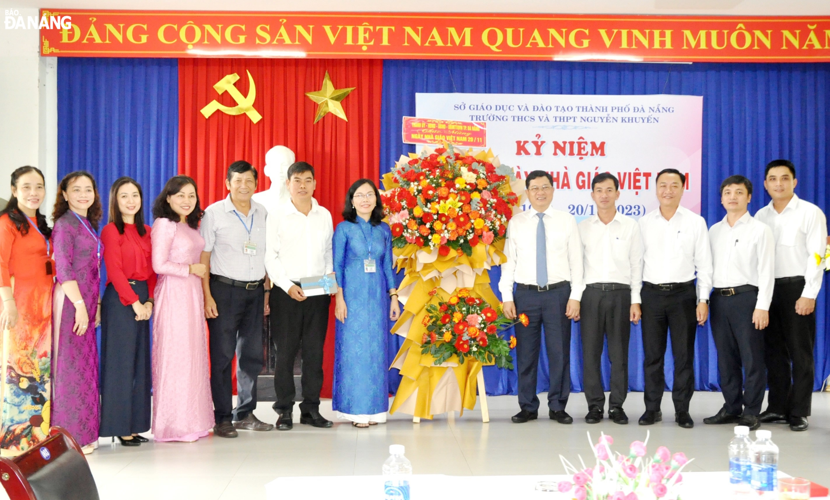 Phó Chủ tịch Thường trực HĐND thành phố Trần Phước Sơn (thứ 5, bên phải sang) tặng hoa chúc mừng Trường THCS-THPT Nguyễn Khuyến. Ảnh: LÊ HÙNG