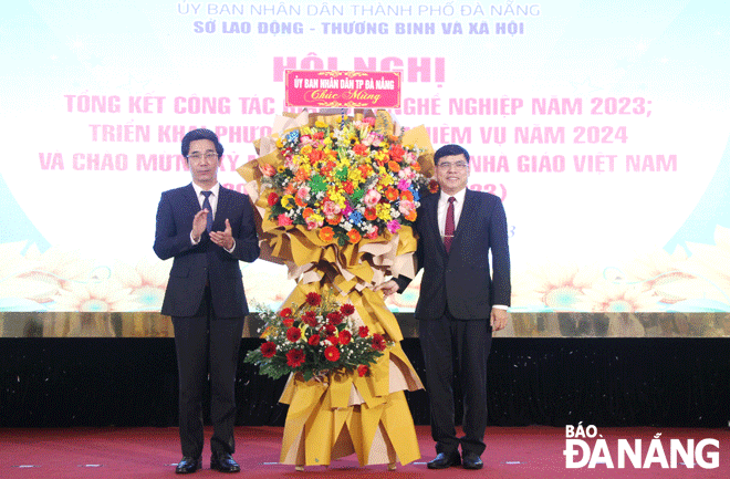 Phó Chủ tịch UBND thành phố Trần Chí Cường (bên trái) tặng hoa chúc mừng nhân ngày Nhà giáo Việt Nam. Ảnh: L.P	