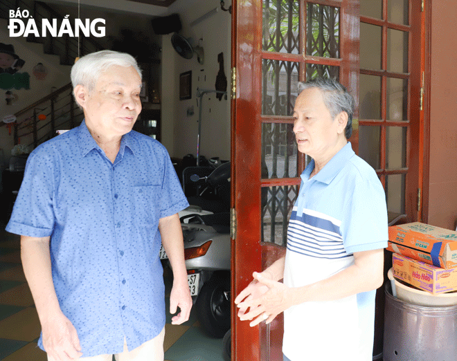 Ông Trần Ngọc Hùng (bên phải) trao đổi với người dân trong tổ dân phố. Ảnh: NGỌC PHÚ