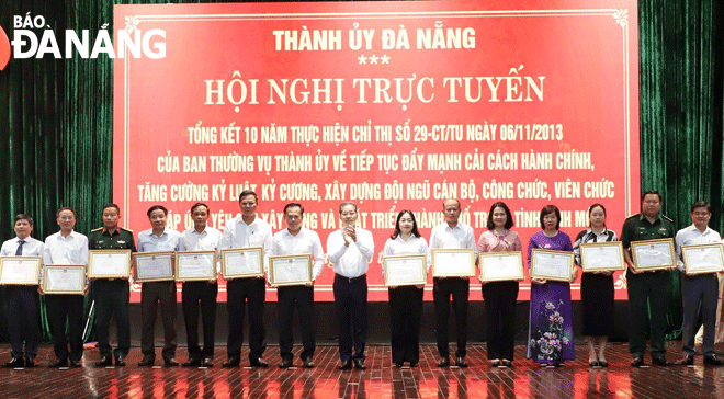 Bí thư Thành ủy Nguyễn Văn Quảng (giữa) trao Bằng khen của UBND thành phố cho các tập thể đạt thành tích xuất sắc trong 10 năm thực hiện Chỉ thị số 29-CT/TU của Thành ủy.  Ảnh: N.PHÚ