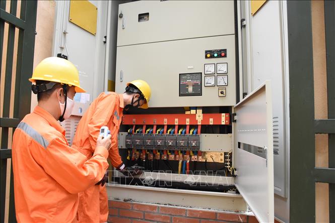 Các công nhân EVNHANOI kiểm tra mối nối cấp điện trên địa bàn Hà Nội. Ảnh: TTXVN phát