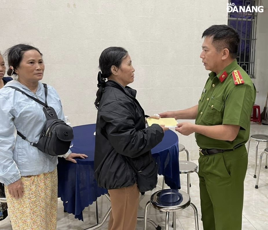 Đại tá Nguyễn Văn Tặng (bên phải) thăm hỏi và trao hỗ trợ cho gia đình nạn nhân Trần Minh Thành. Ảnh: L.H