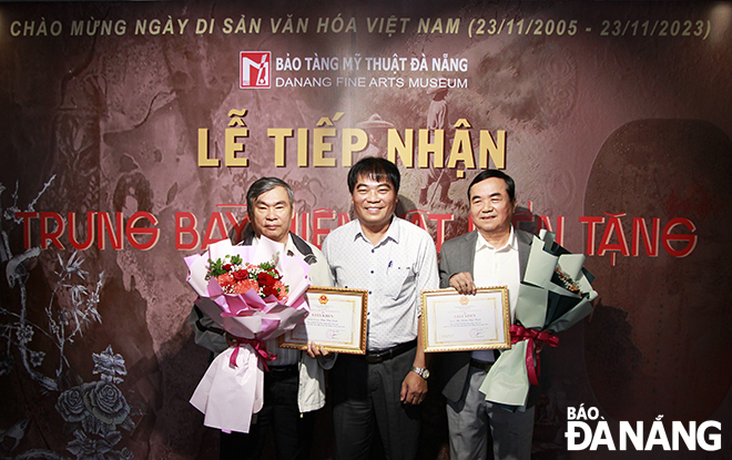 Deputy Director of the Da Nang Department of Culture and Sports Nguyen Trong Thao (middle) presents flowers and certificates to those donating artifacts to the Da Nang Museum of Fine Arts in 2023. Photo: X.D