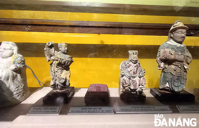 “Lịnh phù Bắc Đế” (giữa) được trưng bày chung trong tủ kính với các tượng thần. Ảnh: T.M