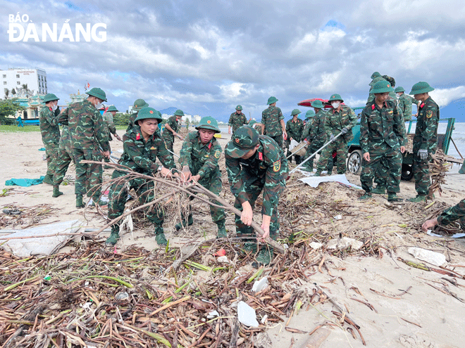 Cán bộ, chiến sĩ lực lượng vũ trang ra quân dọn dẹp rác thải tại bãi biển Nguyễn Tất Thành. Ảnh: L.H