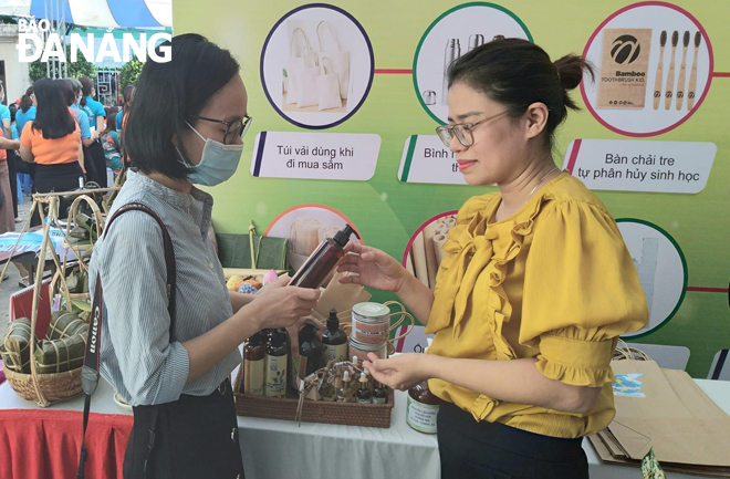 Chị Phan Dạ Thảo (bên phải) giới thiệu sản phẩm của mình đến khách hàng tại ngày hội “Sản phẩm tiêu biểu xanh, thân thiện môi trường” do Hội Liên hiệp Phụ nữ thành phố Đà Nẵng tổ chức