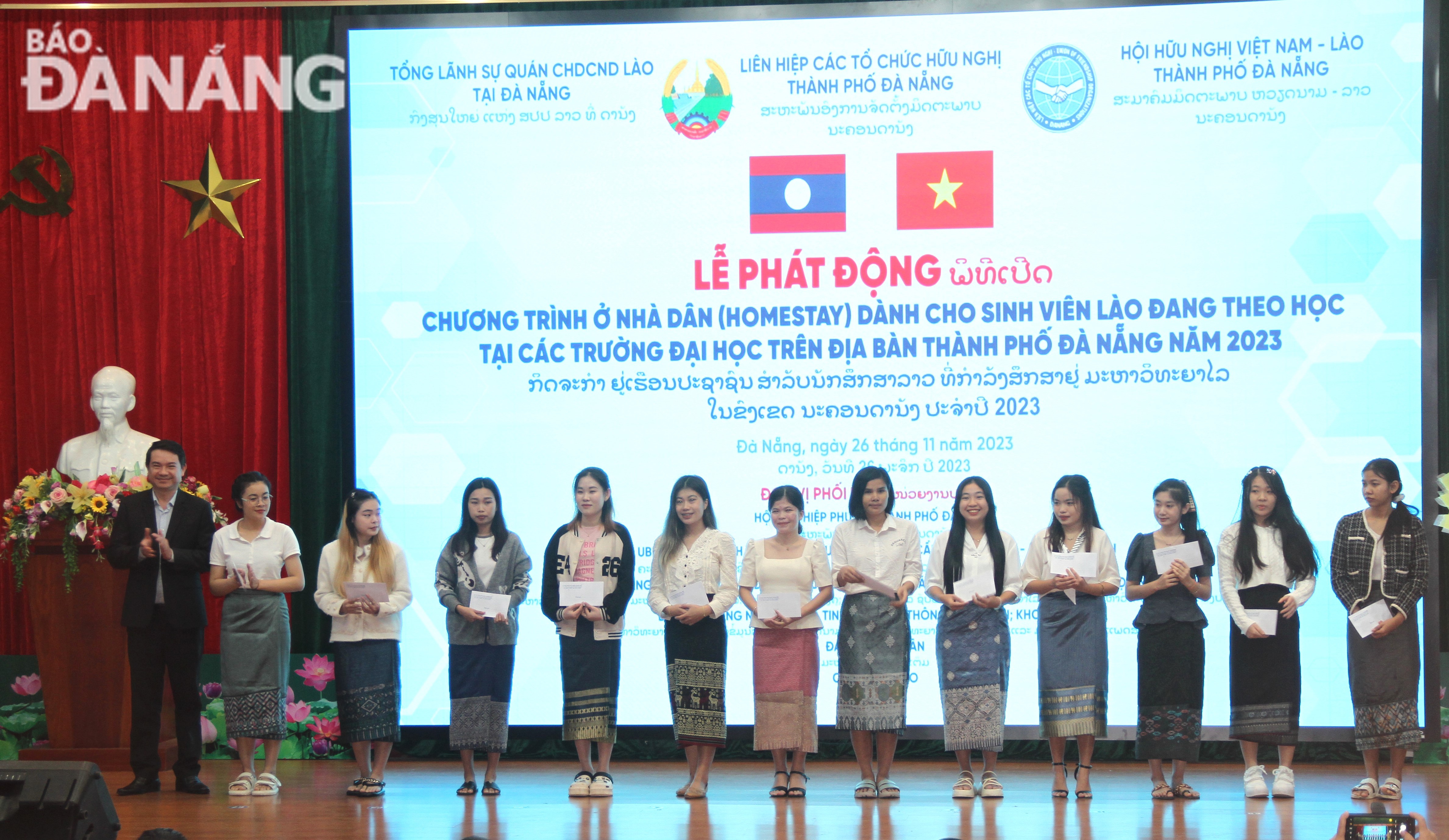 A representative of Thanh Khe District People's Committee receives and gives financial support to Lao students participating in the homestay programme. Photo: LP