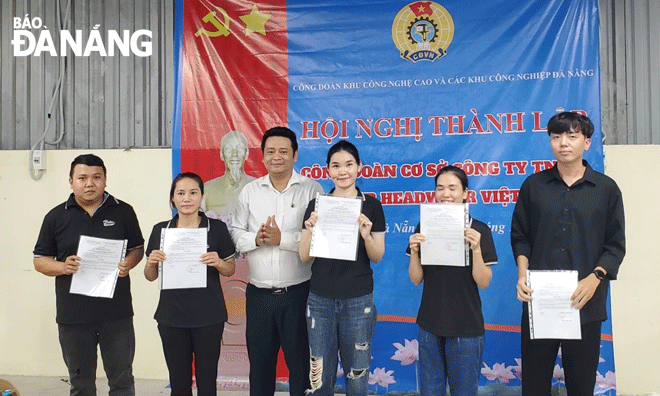 Chủ tịch Công đoàn Khu Công nghệ cao và các khu công nghiệp Đà Nẵng Nguyễn Thành Trung (thứ 3, bên trái sang) trao quyết định gia nhập Công đoàn cho người lao động Công ty TNHH Baller Headwear Việt Nam. Ảnh: X.H