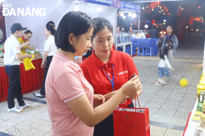 People participate in a cashless payment market combined with launching ‘Online Friday Shopping Day’ at the park on the east bank of Dragon Bridge on the evening of December 1. Photo: VAN HOANG