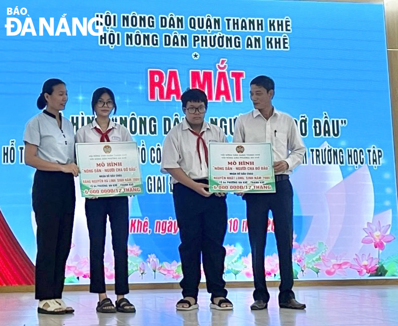 The Farmers' Association of An Khe Ward, Thanh Khe District, provides financial support for Dang Nguyen Ha Linh (2nd, left) and Nguyen Nhat Long (3rd, left). Photo: T.H