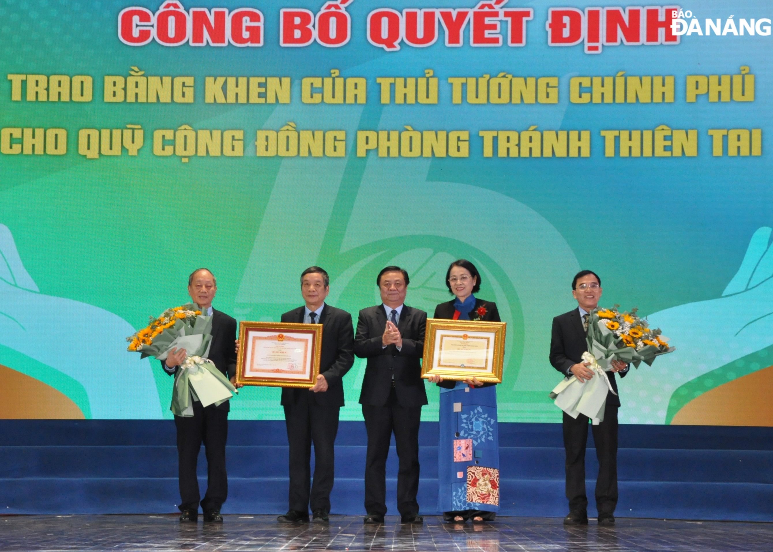 Bộ trưởng Bộ Nông nghiệp và Phát triển nông thôn Lê Minh Hoan (giữa) tặng bằng khen cho Quỹ Cộng đồng phòng tránh thiên tai. Ảnh: LÊ HÙNG