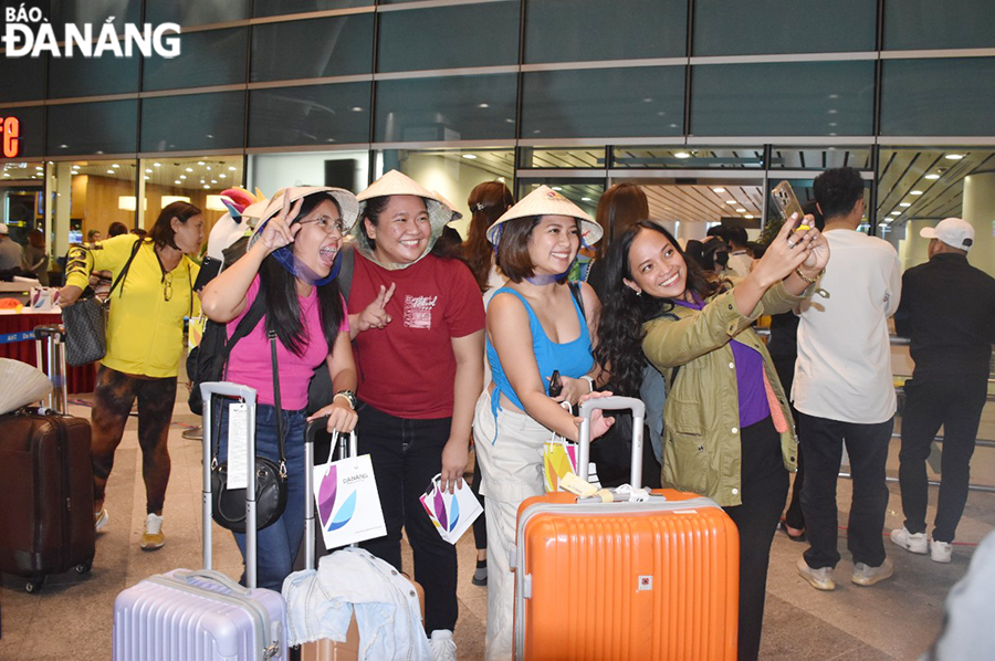 Passengers on the first flight from the Philippines' Manila happily take photos at Da Nang International Airport. Photo: THU HA