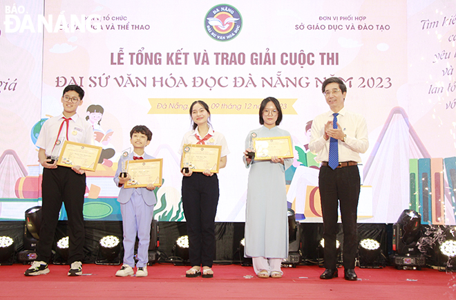Phó Chủ tịch UBND thành phố Trần Chí Cường (bên phải, ngoài cùng) trao giải Đại sứ văn hóa đọc Đà Nẵng cho các em học sinh. Ảnh: X.D