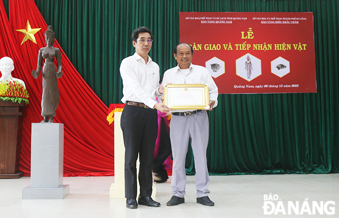 Phó Chủ tịch UBND thành phố Trần Chí Cường (bên trái) tặng bằng khen cho chính quyền và nhân dân thôn Đồng Dương. Ảnh: X.D